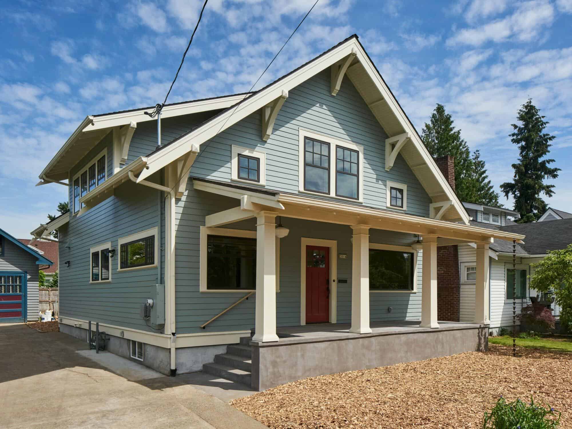 britton-exterior side A beautifully remodeled blue craftsman-style house with a welcoming porch, showcasing the quality work of ReCraft Home Remodeling in Portland, Oregon.