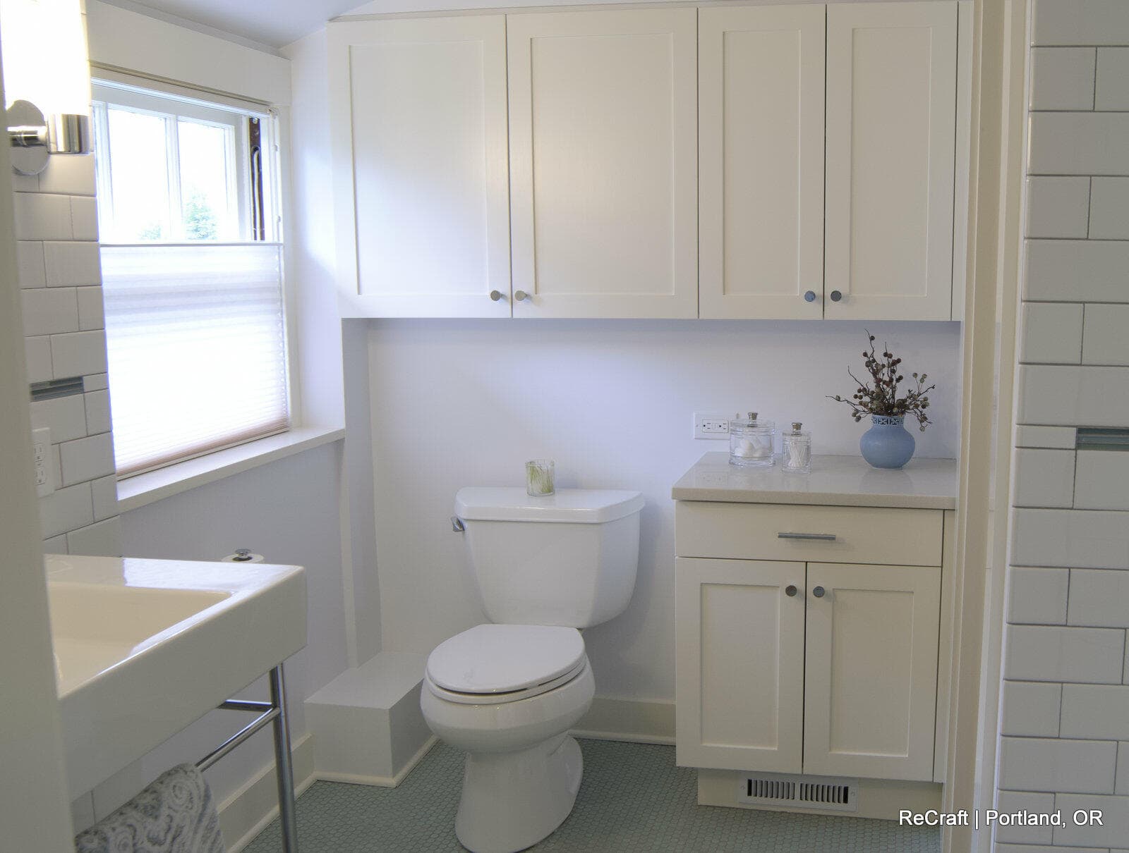 Modern bathroom design featuring white cabinetry, a toilet, and a sink, showcasing ReCraft Home Remodeling's craftsmanship in Portland.