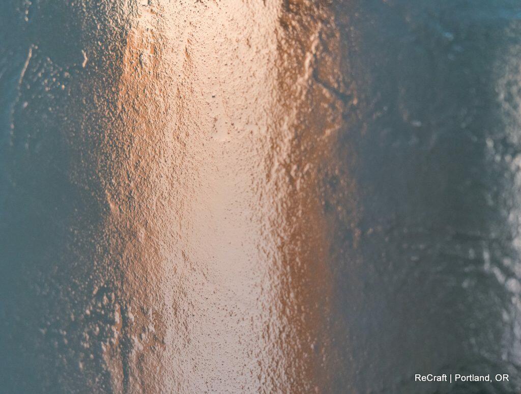 Close-up image of a textured surface with a mix of warm and cool tones, likely a wall or artwork. Text in the lower right corner reads "ReCraft | Portland, OR. Close-up image of a textured surface with a mix of warm and cool tones, likely a wall or artwork. Text in the lower right corner reads "ReCraft | Portland, OR.