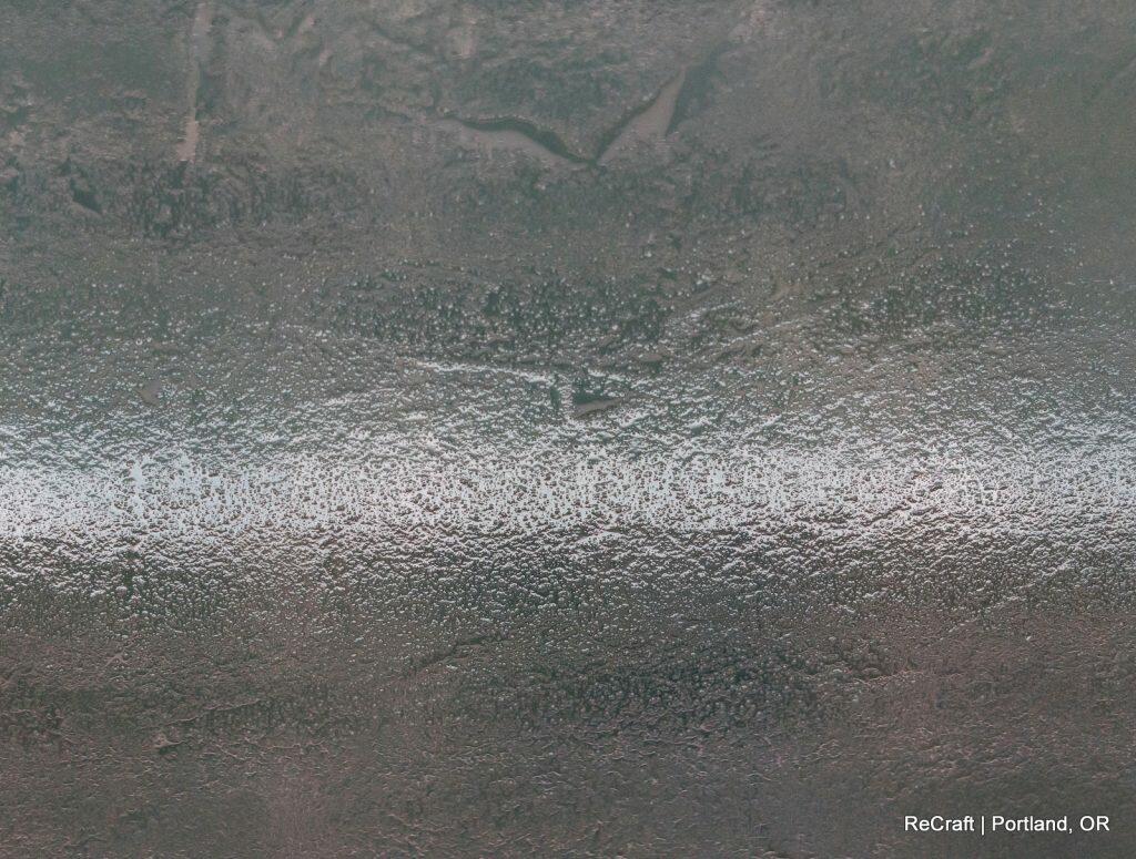 A textured metallic surface with a horizontal line dividing a rougher top section from a shinier bottom section. The text "ReCraft | Portland, OR" is in the bottom right corner. A textured metallic surface with a horizontal line dividing a rougher top section from a shinier bottom section. The text "ReCraft | Portland, OR" is in the bottom right corner.