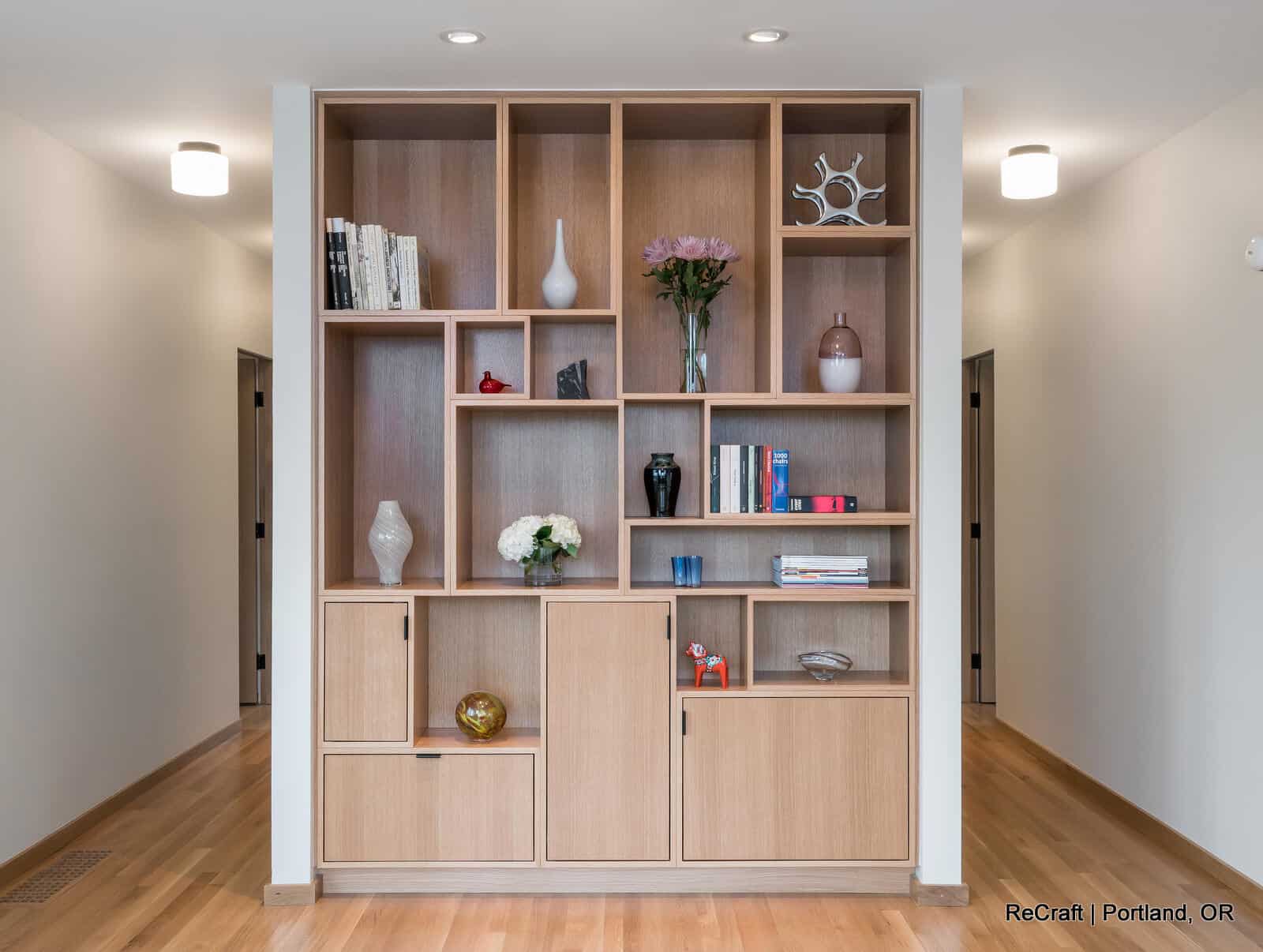 mcconnell - shelving_full Modern wooden shelving unit with decorative items and plants, showcasing interior design from ReCraft Home Remodeling in Portland, Oregon.