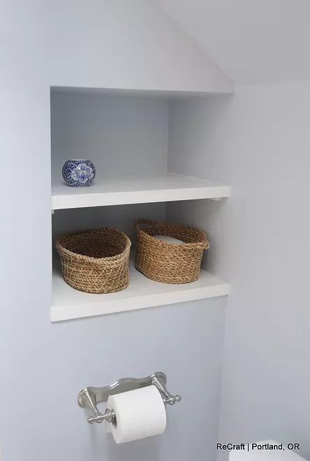 Modern bathroom shelving with decorative items and woven baskets, showcasing ReCraft Home Remodeling's design style in Portland.