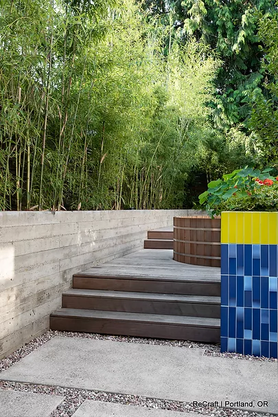 Modern garden design featuring bamboo, textured concrete walls, and colorful tile accents in a Portland home remodeling project by ReCraft Home Remodeling.