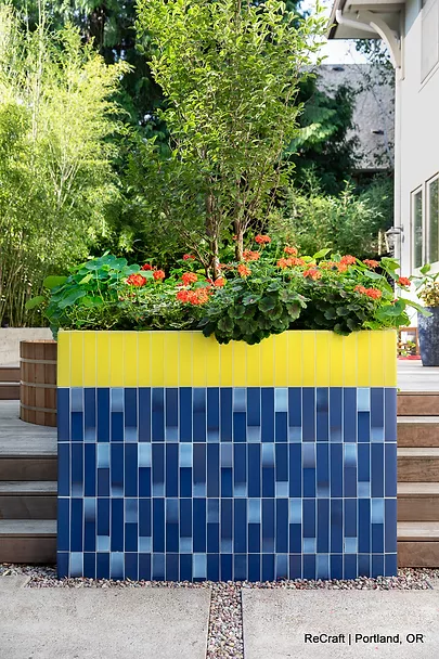 Colorful planter box with blue tile design and vibrant flowers, showcasing ReCraft Home Remodeling's outdoor remodeling work in Portland, OR.