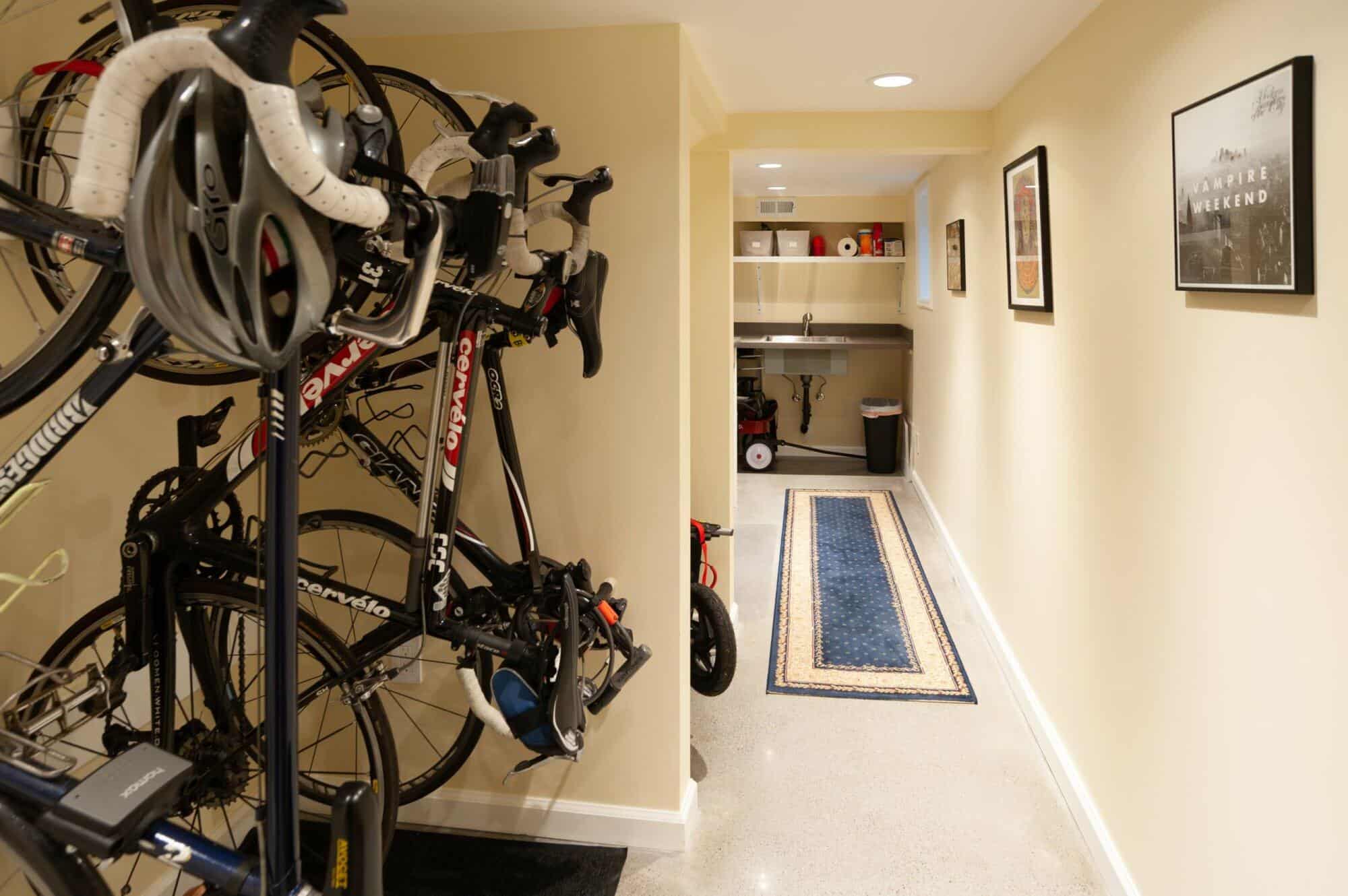 Basement hallway featuring mounted bicycles, storage area, and decorative wall art, illustrating a functional and stylish remodeling by ReCraft Home Remodeling in Portland.