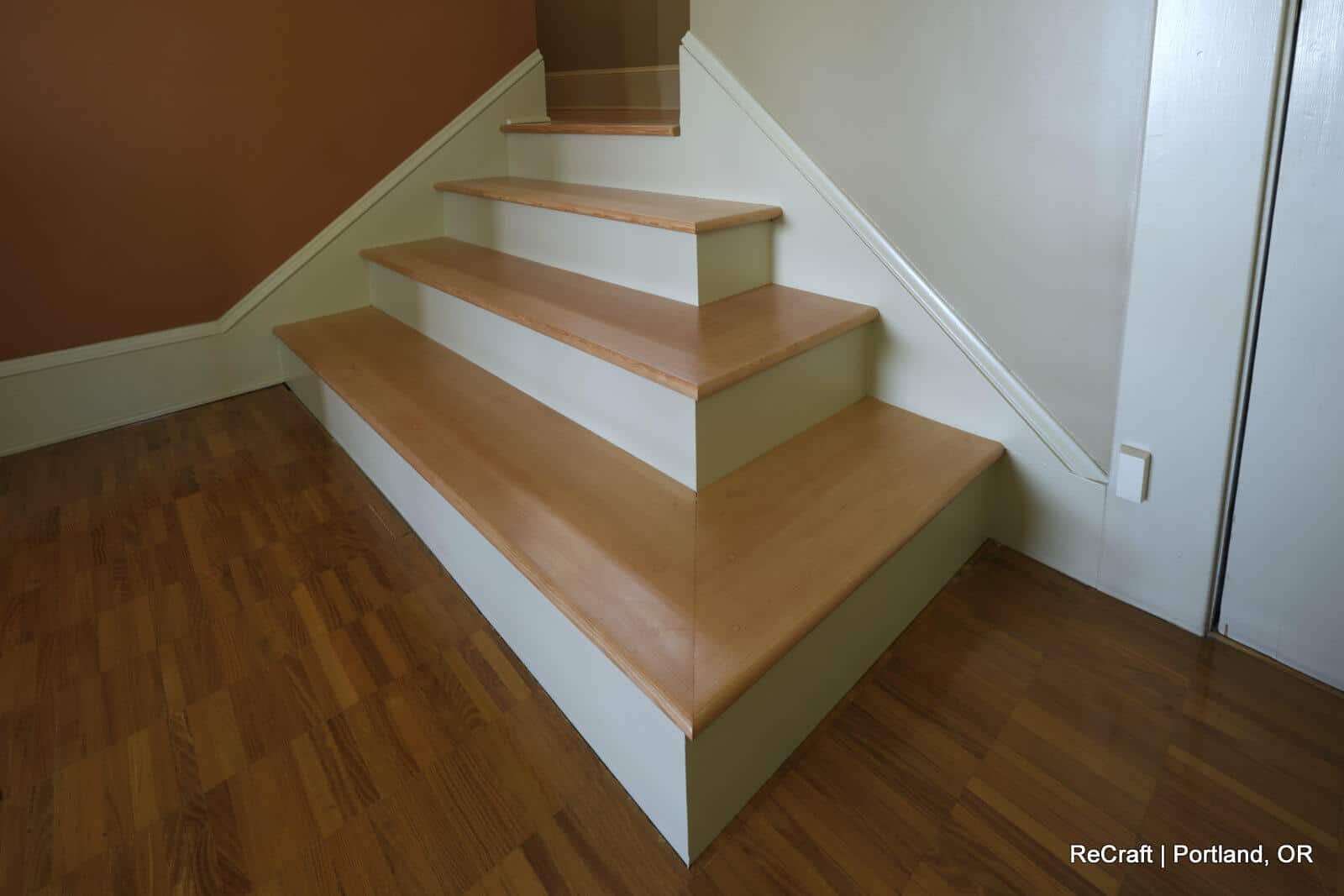 Stunning wooden staircase with multiple steps leading to an upper level, showcasing ReCraft Home Remodeling's craftsmanship in basement renovations in Portland.