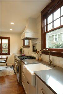 A modern kitchen featuring a farmhouse sink, stainless steel appliances, a gas stove with a range hood, ample counter space, and a large window providing natural light. A modern kitchen featuring a farmhouse sink, stainless steel appliances, a gas stove with a range hood, ample counter space, and a large window providing natural light.