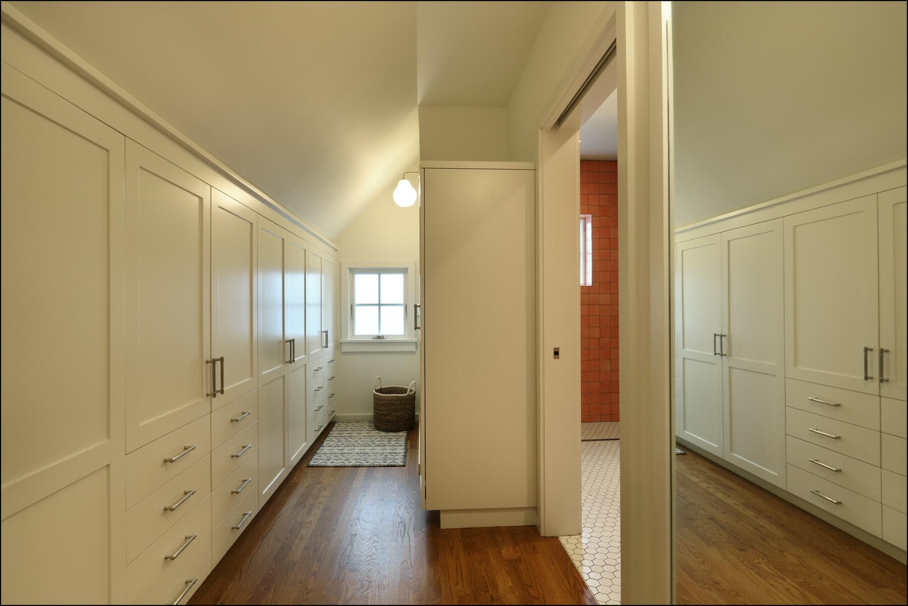 Interior view of a remodeled hallway featuring white cabinetry, hardwood flooring, and natural light from windows, showcasing ReCraft Home Remodeling's design expertise in whole house renovations.