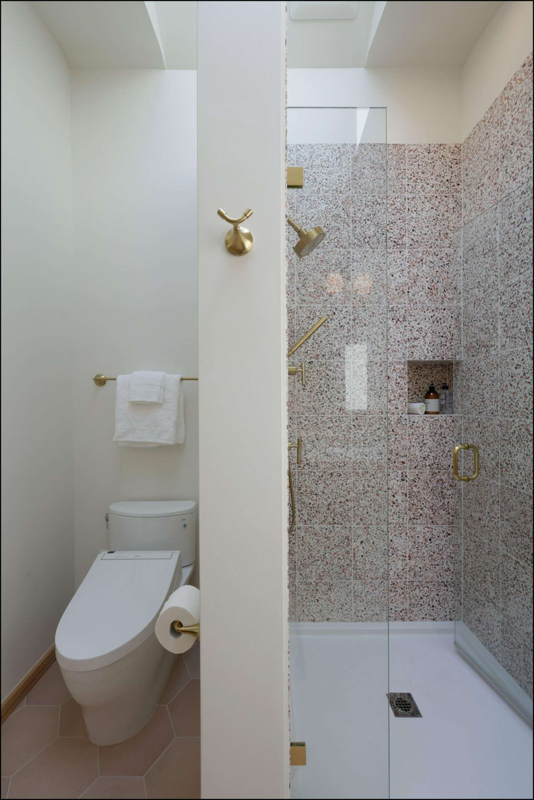 Modern bathroom design featuring a glass shower enclosure and a sleek toilet, showcasing elegant fixtures and textured wall tiles, part of ReCraft Home Remodeling's Portland gallery.