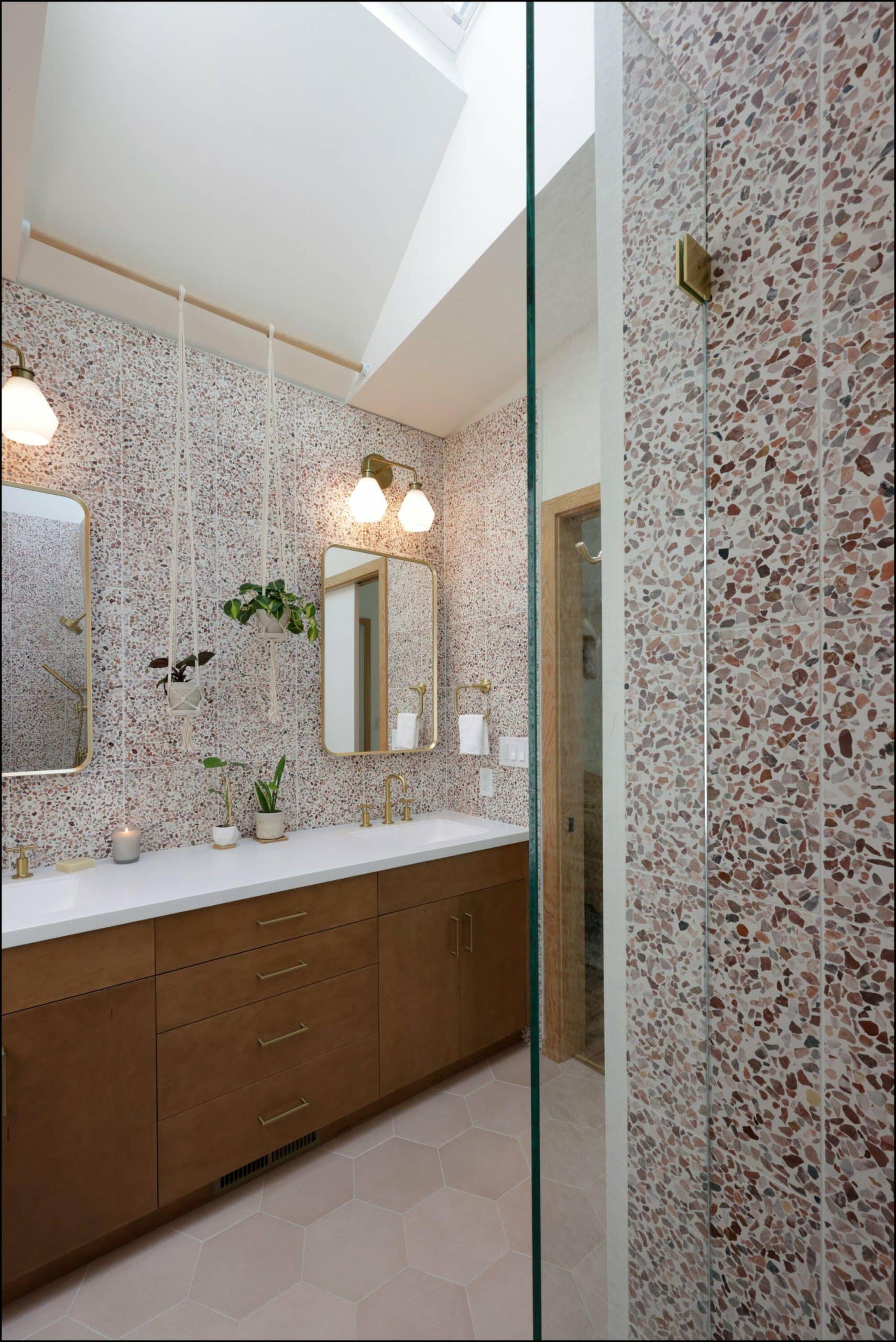 Modern bathroom interior featuring a wooden vanity, elegant lighting fixtures, and textured wall tiles, showcasing ReCraft Home Remodeling's design expertise in Portland bathroom renovations.