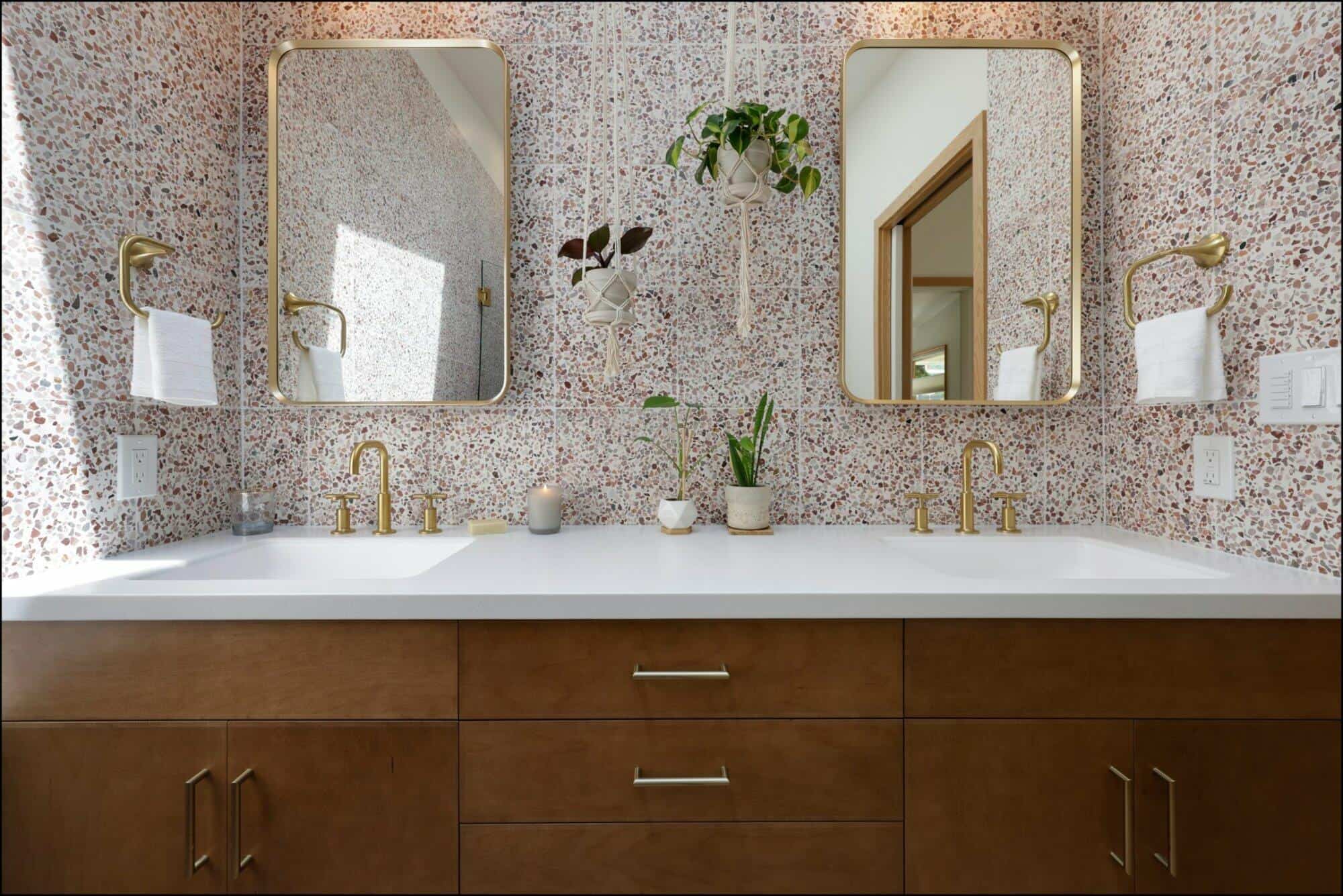 Modern bathroom vanity with dual mirrors, gold fixtures, and a speckled wall design, showcasing ReCraft Home Remodeling's elegant renovation style in Portland.