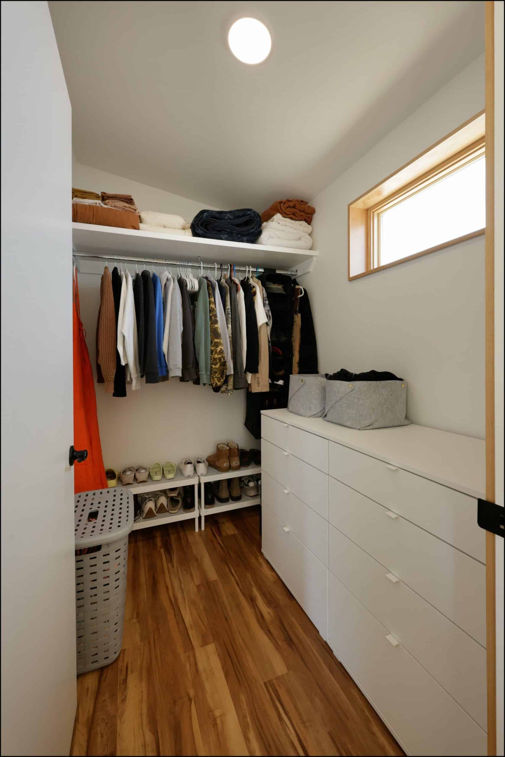 Modern closet storage design featuring organized clothing, shelving, and a drawer unit, showcasing ReCraft Home Remodeling's interior design capabilities in Portland.