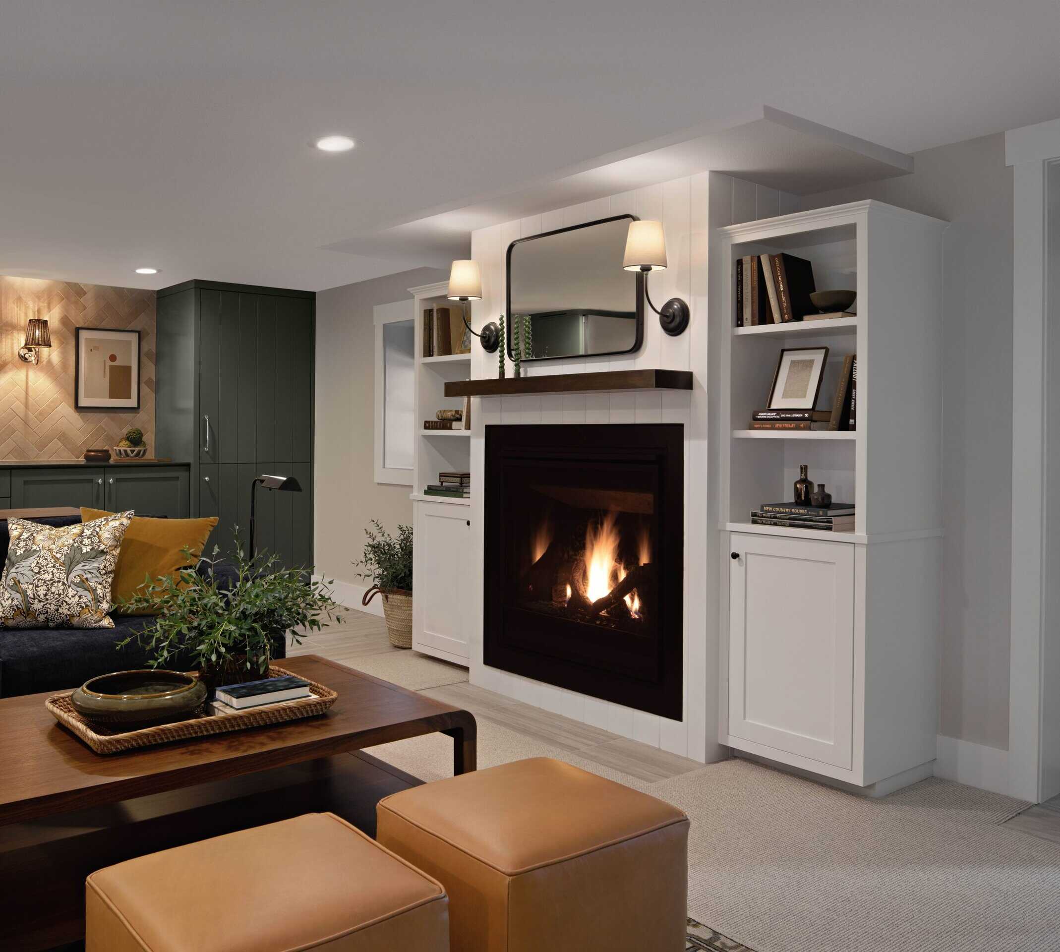 Modern basement living space with cozy fireplace, built-in shelving, and stylish furnishings, showcasing ReCraft Home Remodeling's design expertise in basement renovations.