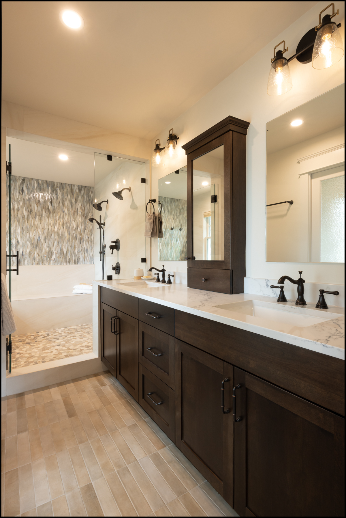 Modern bathroom featuring a double-sink vanity with dark wood cabinets, a marble countertop, and a glass-enclosed shower with mosaic tile accents.