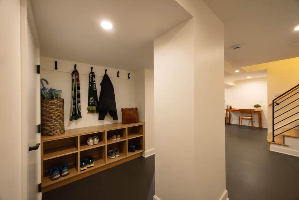 Basement entryway featuring organized shoe storage, coat hooks, and a modern aesthetic, showcasing ReCraft Home Remodeling's design expertise in Portland.