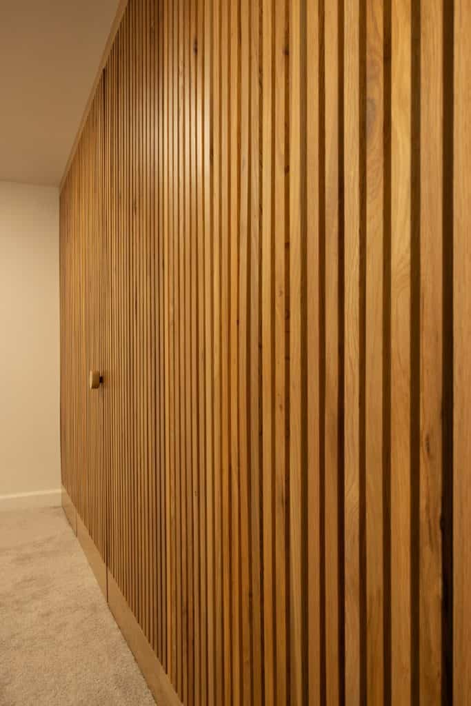 Wooden slat wall in a remodeled basement showcasing modern design elements for ReCraft Home Remodeling projects in Portland.