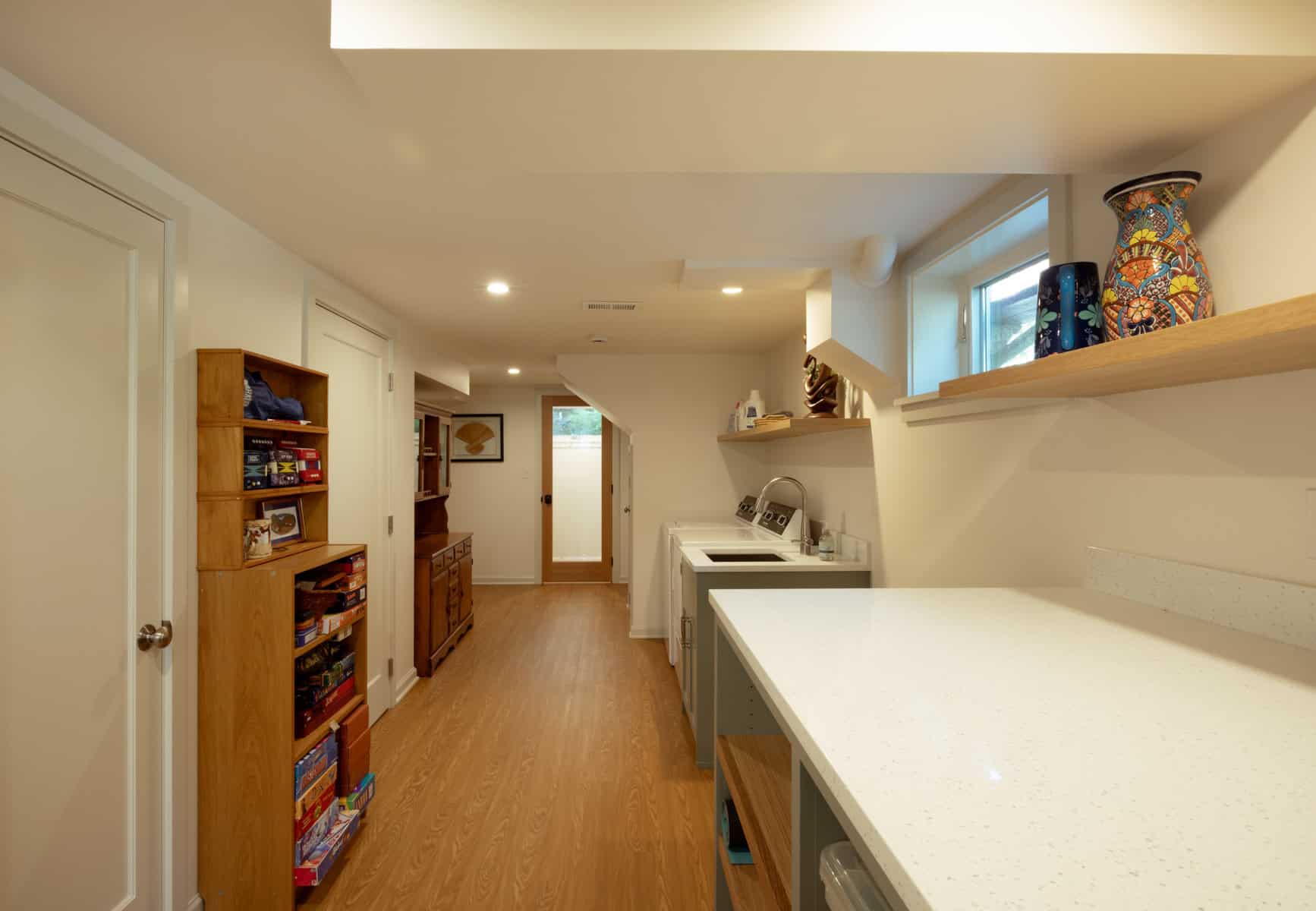 Finished basement renovation with laundry area and shelving in Portland, Oregon.