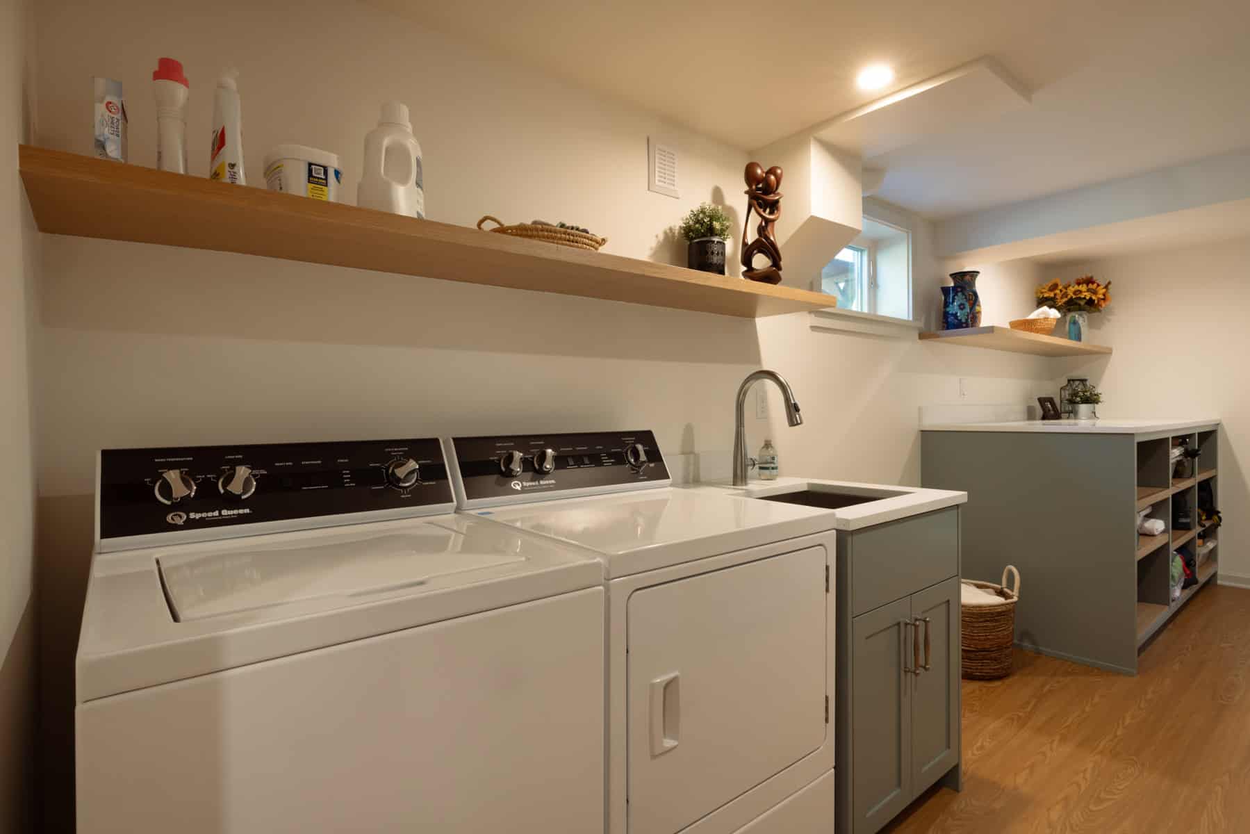 Finished basement laundry room with shelving and modern appliances by ReCraft Home Remodeling in Portland.