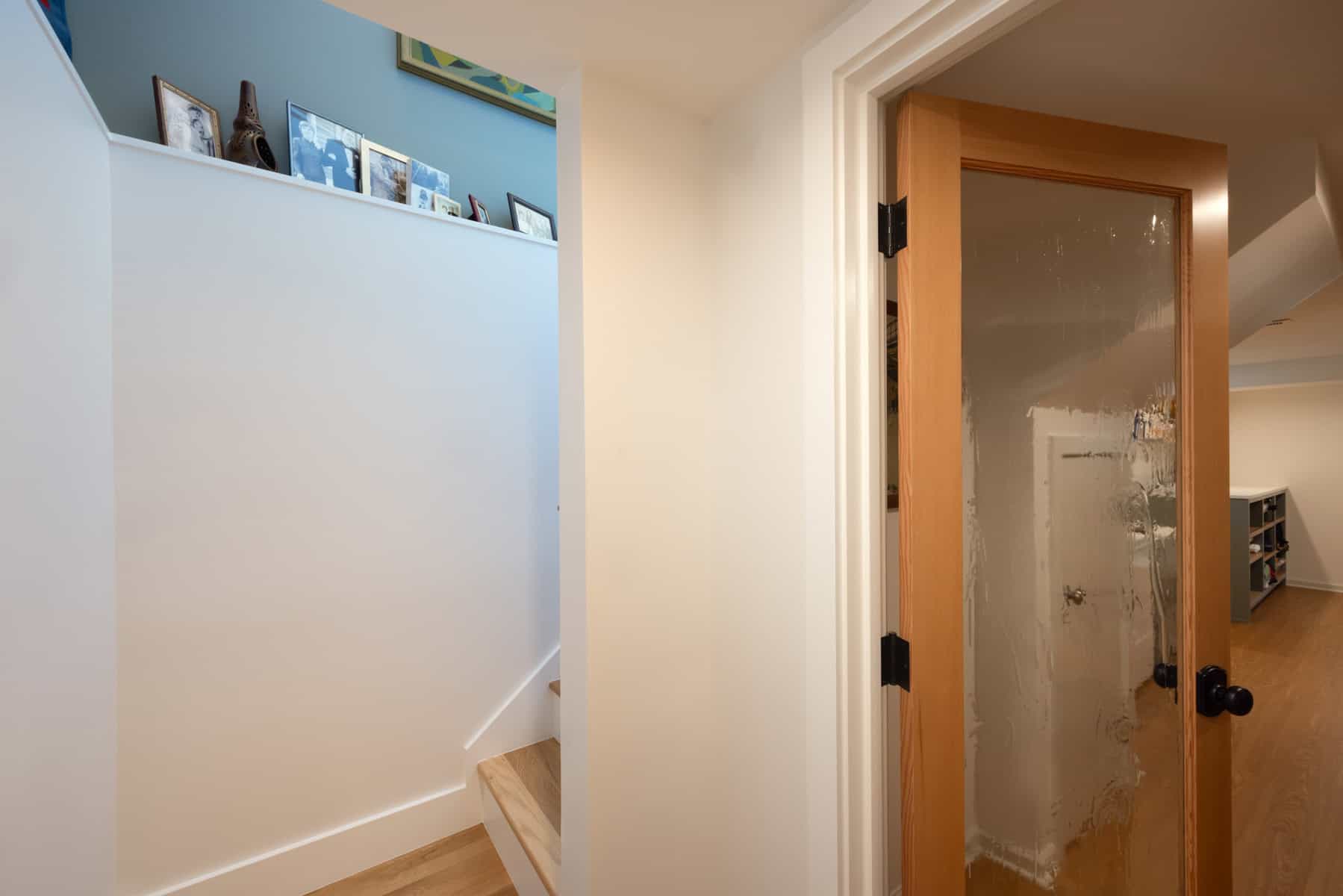 Finished basement renovation with wooden door and staircase in Portland.
