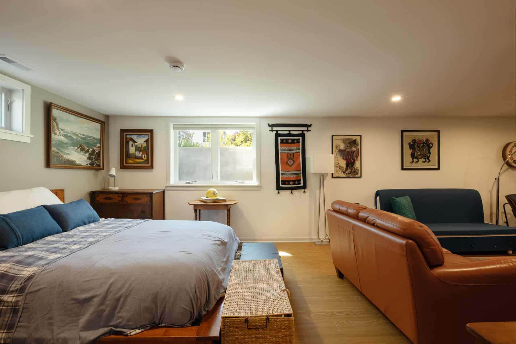 Finished basement renovation in Portland with a bed and sofa.