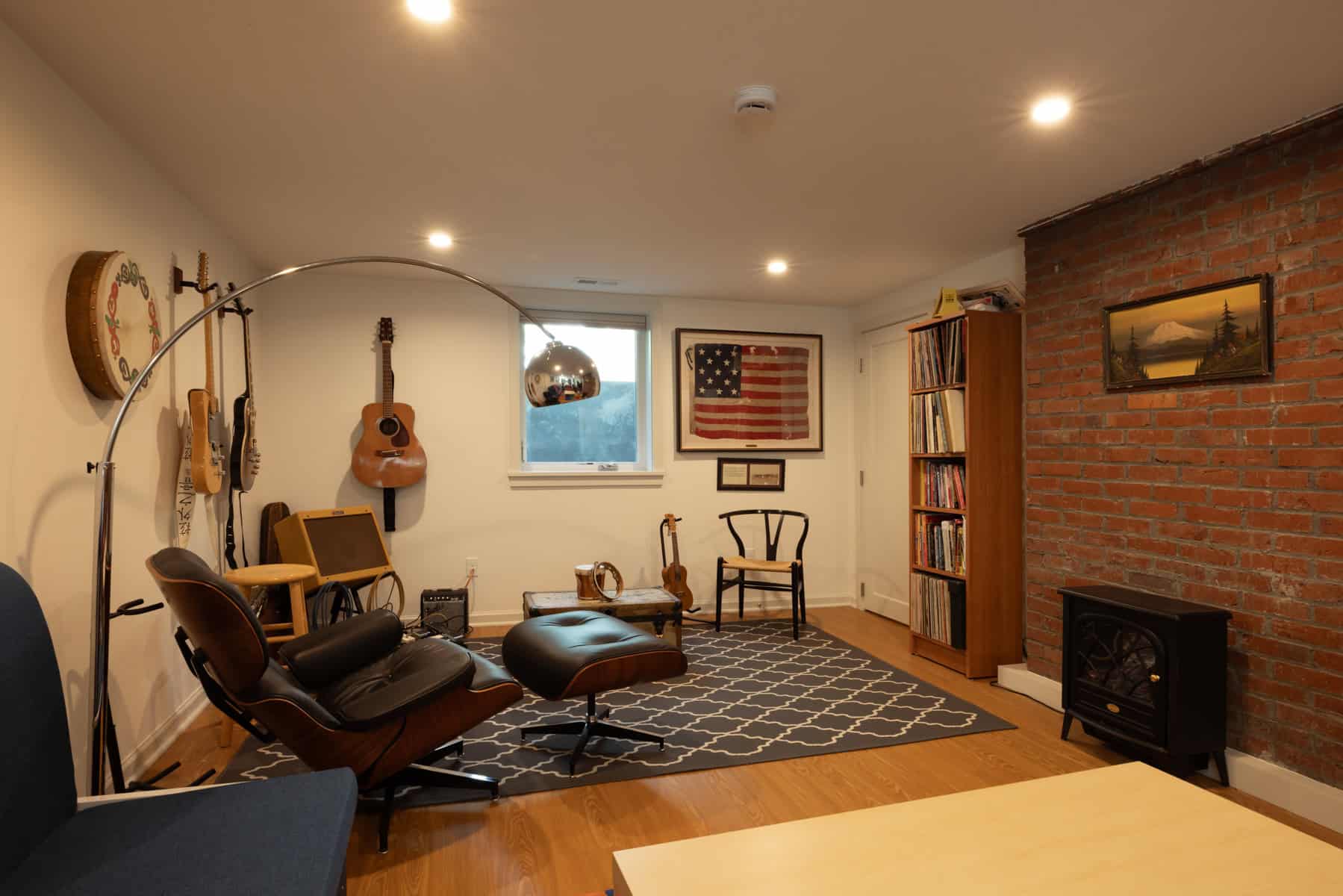 Finished basement entertainment area with brick accent wall and comfortable seating by ReCraft Home Remodeling.